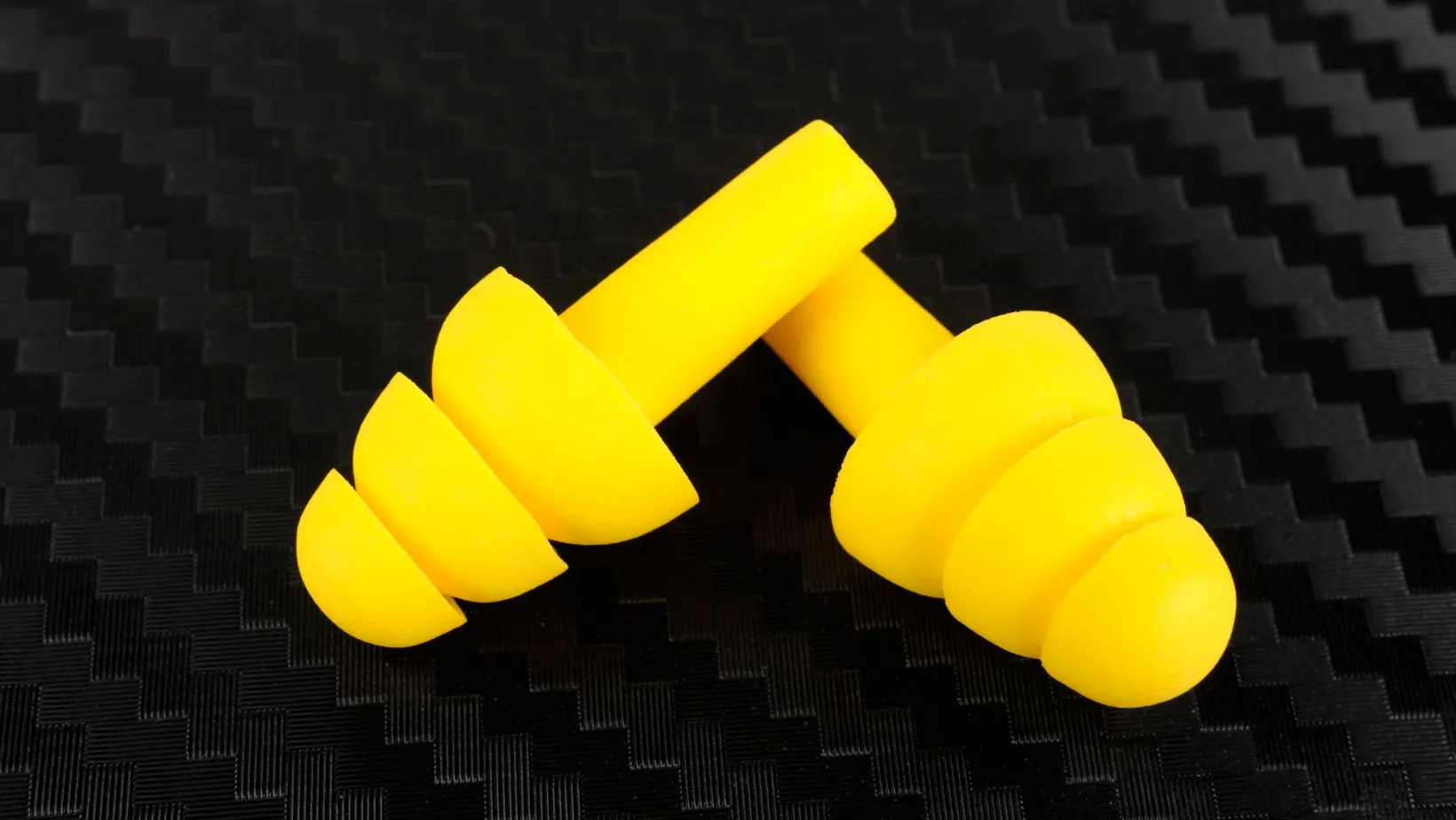 yellow earplugs on black background