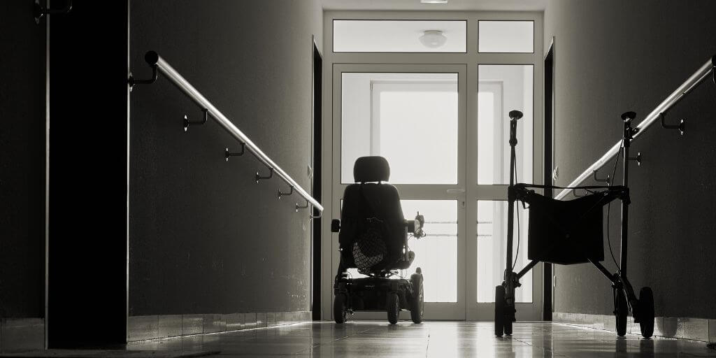 dark hallway with one wheelchair and one electric wheelchair